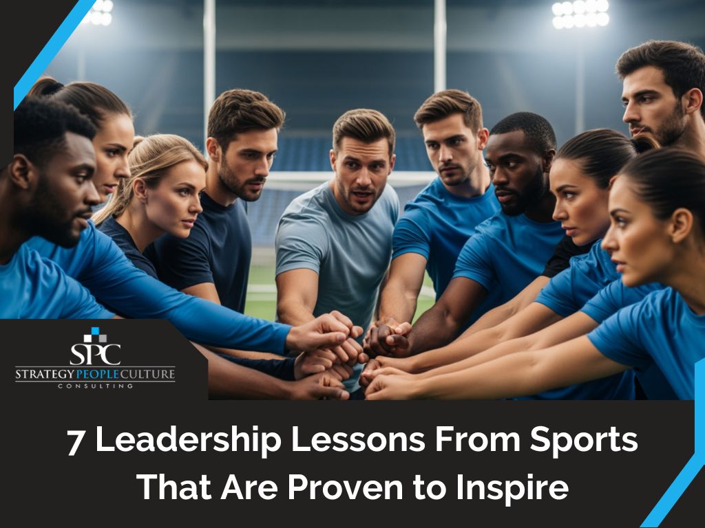 Sports team huddled together on a field with hands joined, symbolizing teamwork and leadership.